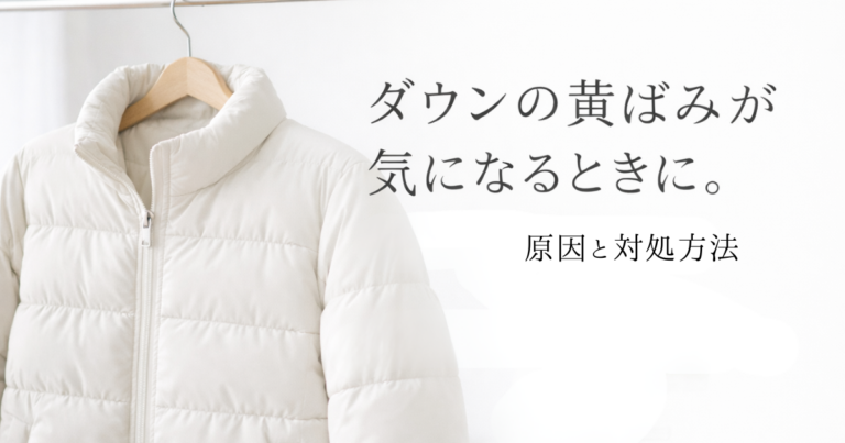 White down jacket hanging on a wooden hanger against a minimal white background with Japanese text about yellowing stains on down jackets.