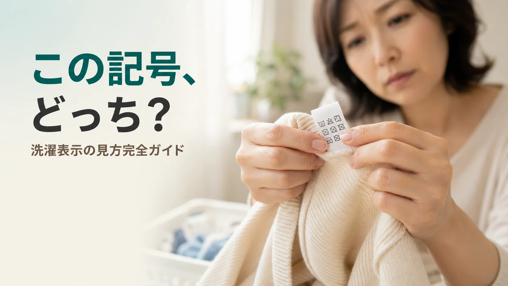 衣類の洗濯表示タグをつまんで、「この記号どっち?」と少し首をかしげながら見つめる女性の手元。家で洗えるか迷う、誰もが経験する日常の一場面を表現。北九州市小倉南区のファミリークリーニング(創業56年)が、新旧の洗濯マークの読み方をわかりやすく解説する記事のアイキャッチ。