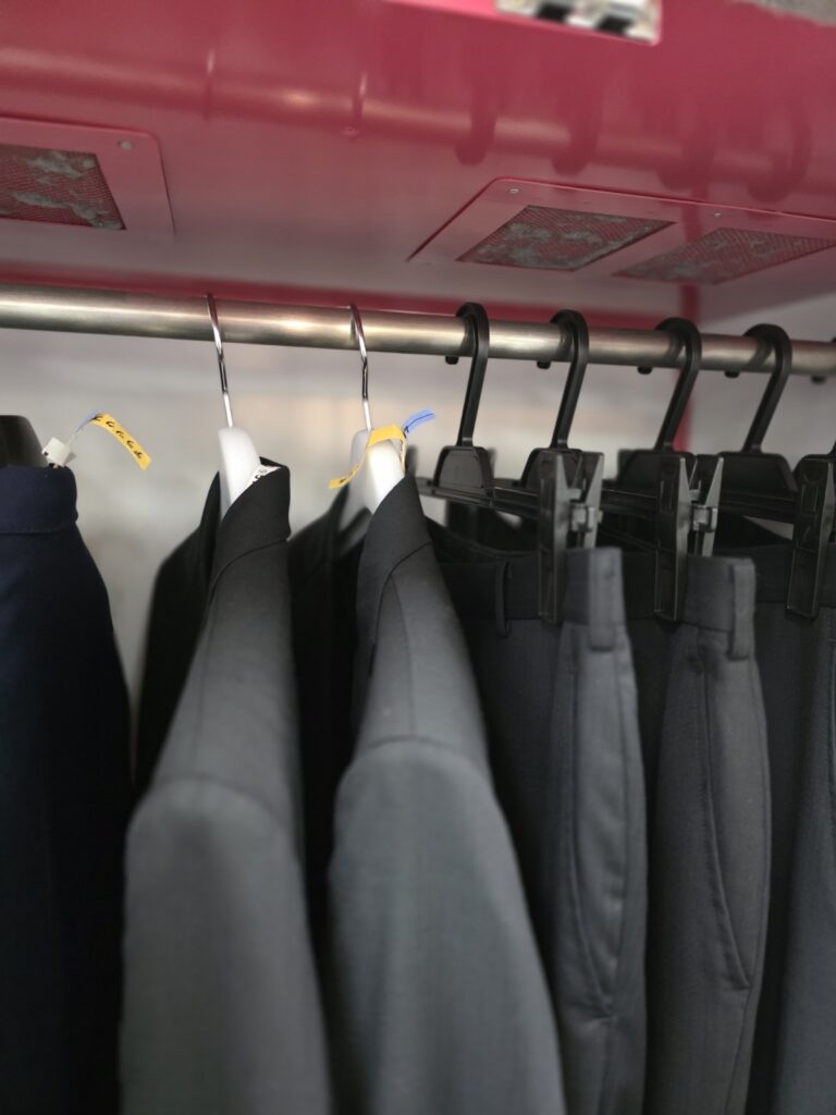 ジャケットやズボンをハンガーに掛けて乾かす、店内の静止立体乾燥設備