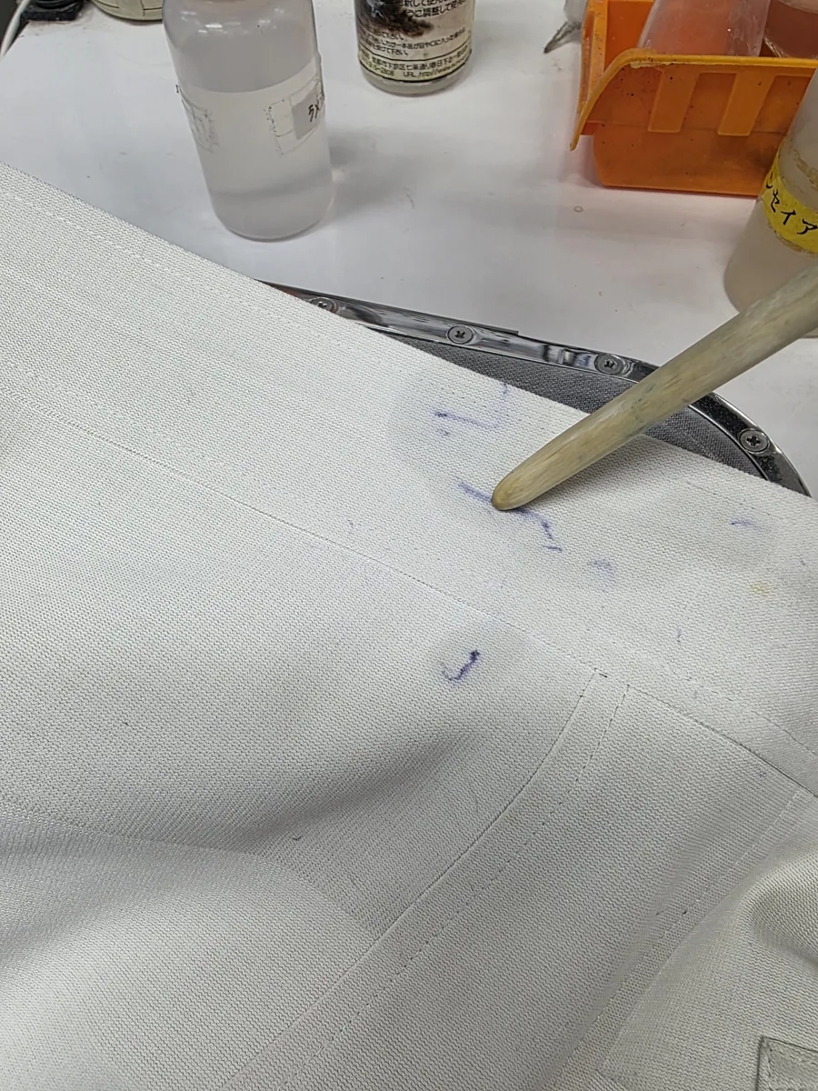溶剤をのせたボールペンの線を、ブラシでたたいてインクを浮かせているところ