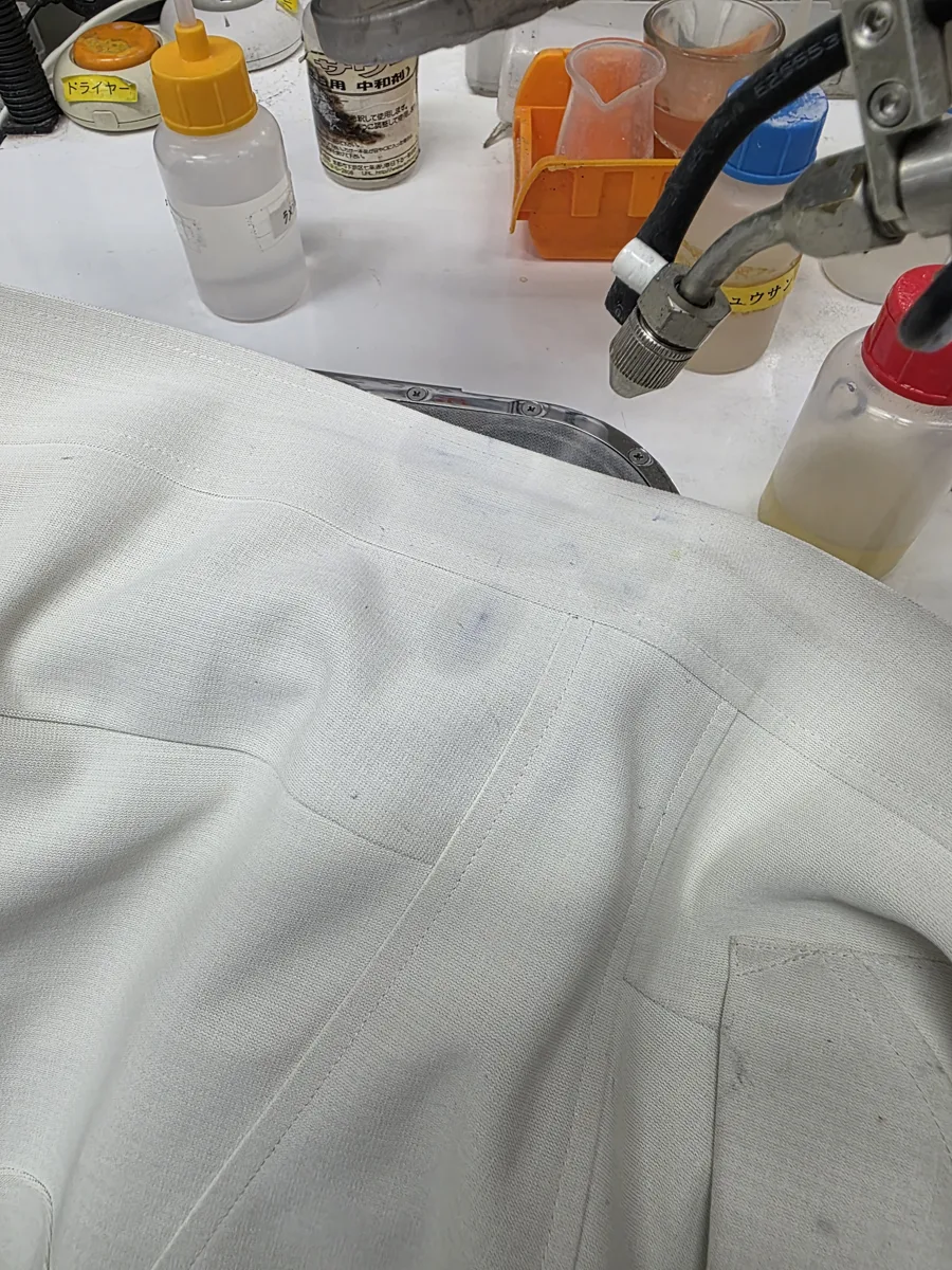 染み抜き台で、白衣に蒸気をあてて仕上げているところ